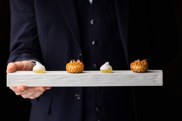 Service de desserts raffinés au Domaine du Liziec, assortiment de pâtisseries sur plateau blanc dans un cadre élégant