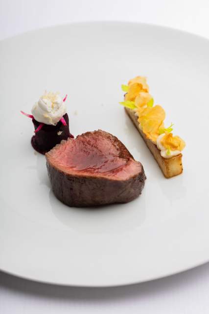 Plat gastronomique au Domaine du Liziec avec viande cuite à point, purée crémeuse et accompagnement raffiné sur assiette blanche