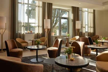 Espace lounge lumineux du Domaine du Liziec avec grandes baies vitrées et fauteuils confortables