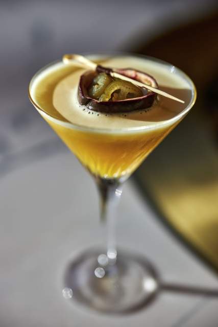 Cocktail exotique au Domaine du Liziec, servi dans un verre à martini avec garniture de fruit de la passion