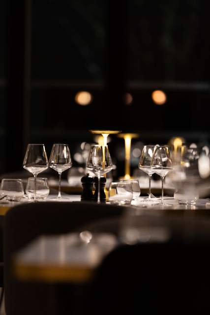 Table de dîner au Domaine du Liziec avec verrerie élégante, bougies et ambiance chaleureuse en lumière tamisée