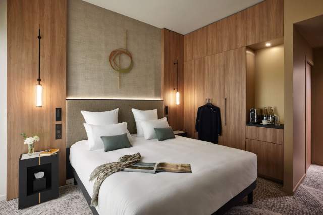 Chambre moderne du Domaine du Liziec avec lit double, décoration naturelle, armoire ouverte et ambiance cosy