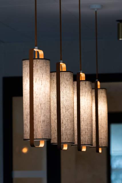 Suspensions lumineuses au Domaine du Liziec, lampes cylindriques en tissu diffusant une lumière chaude dans un décor feutré