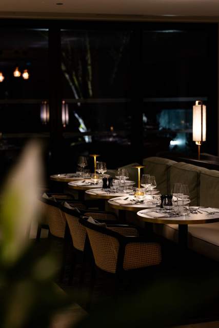 Salle de restaurant gastronomique <span><span><span><span>1 Étoile Michelin </span></span></span></span>intimiste du Domaine du Liziec avec tables élégamment dressées, éclairage doux et ambiance sophistiquée