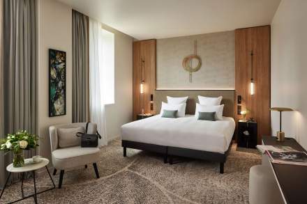 Chambre moderne au Domaine du Liziec avec deux lits simples, décoration boisée, éclairage doux et touches de vert