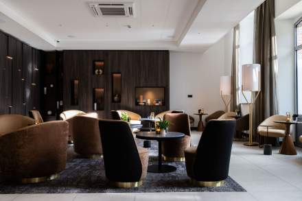 Salon élégant du Domaine du Liziec avec fauteuils design et ambiance chaleureuse près de la cheminée